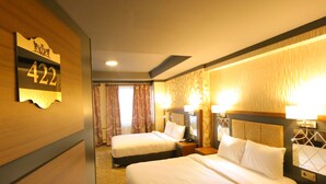 A hotel room with two beds, a number sign, and a patterned carpet. - Taht Palace Hotel (Van)