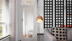 Un soggiorno moderno con un divano grigio, un cuscino decorativo e una lampada da terra.