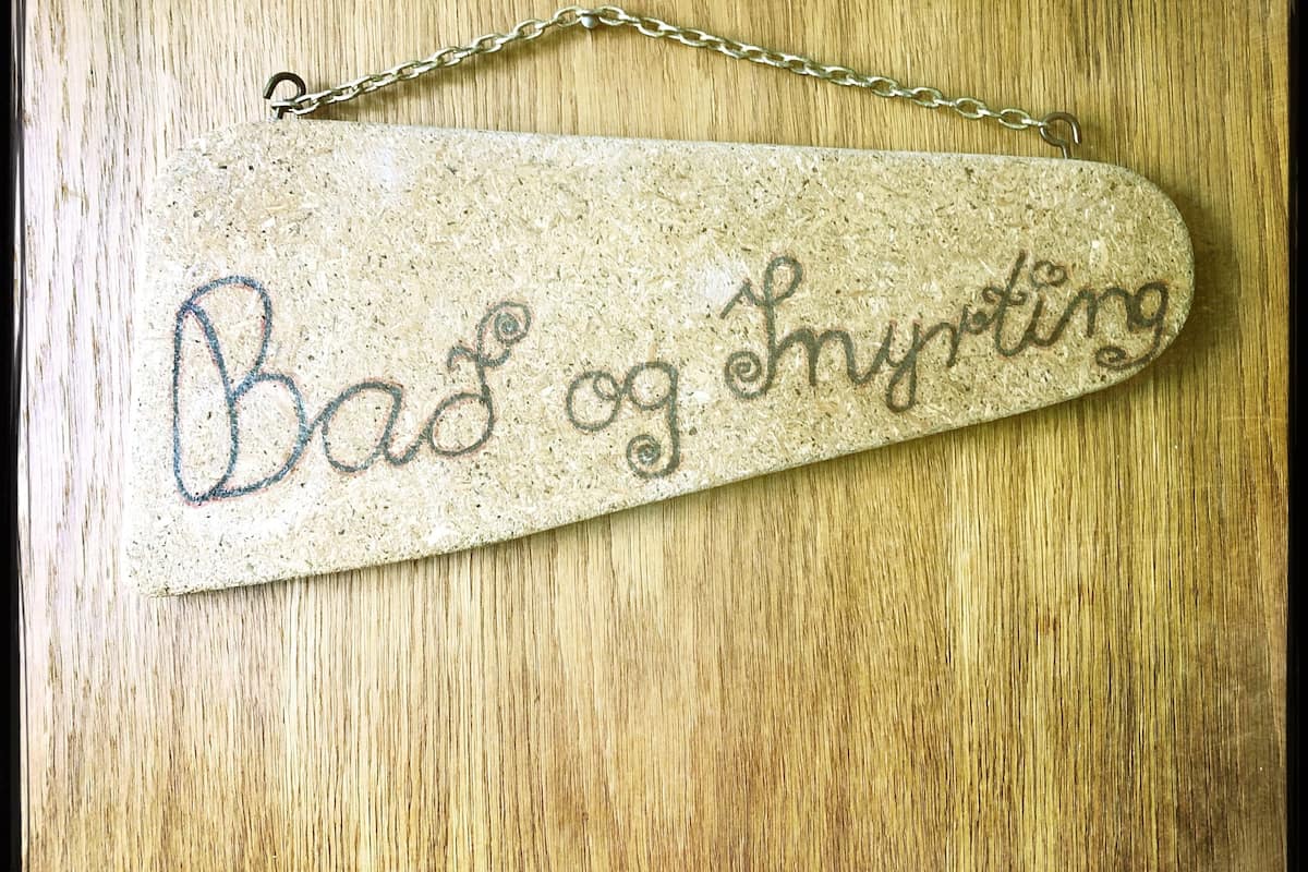 Un letrero de madera con el texto 'Bad og Strykt'.