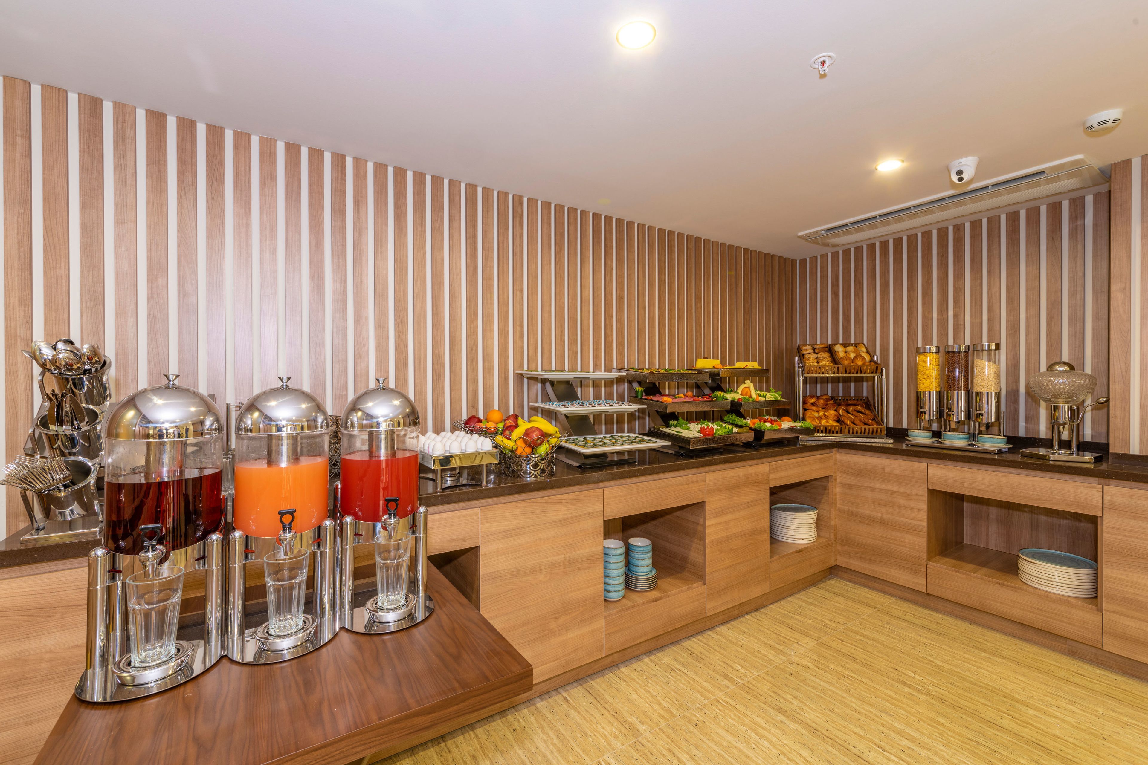 A buffet setup with various food items and drink dispensers.