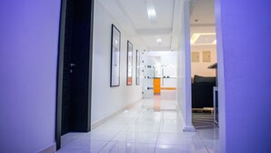 A modern hotel corridor with a clean, polished floor, framed artwork on the walls, and a bright interior. - Ziroc Residence (Lekki)