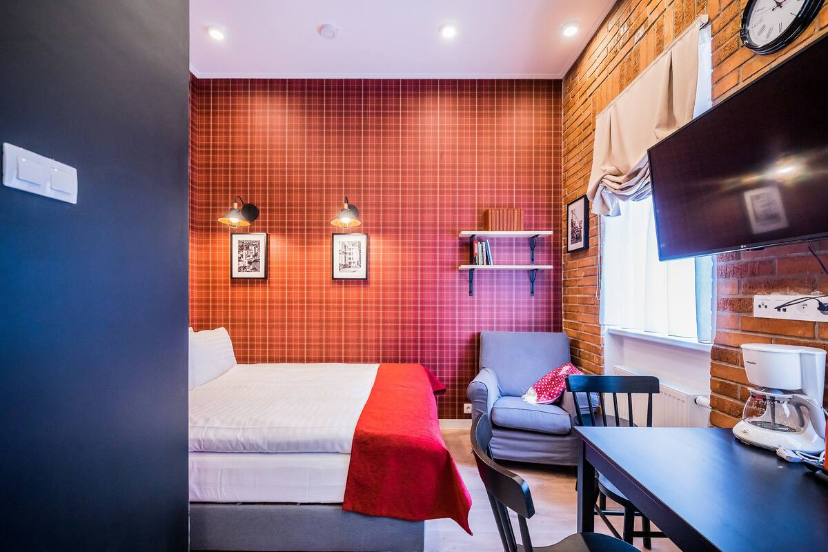 Une chambre d’hôtel avec deux lits, un bureau, une chaise, une télévision et une bibliothèque.