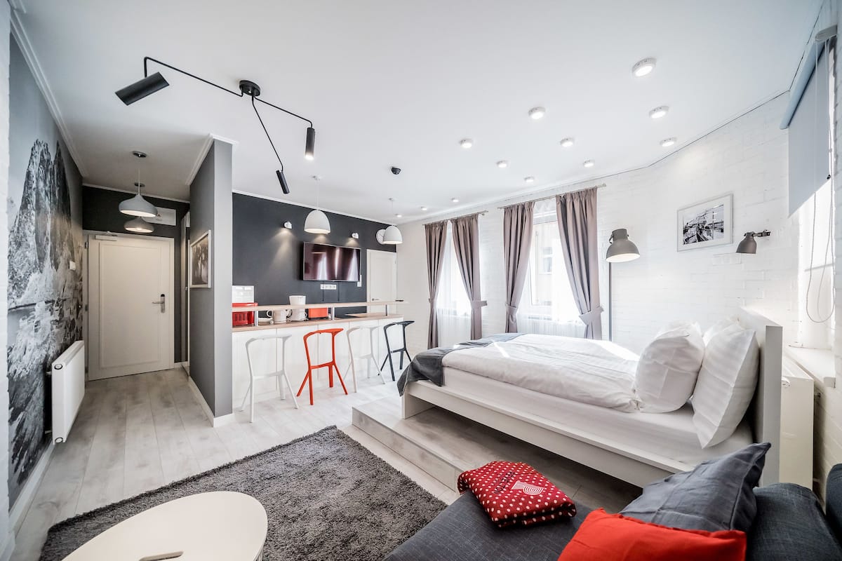 Une chambre moderne équipée d’un lit, d’un bureau et d’une kitchenette.