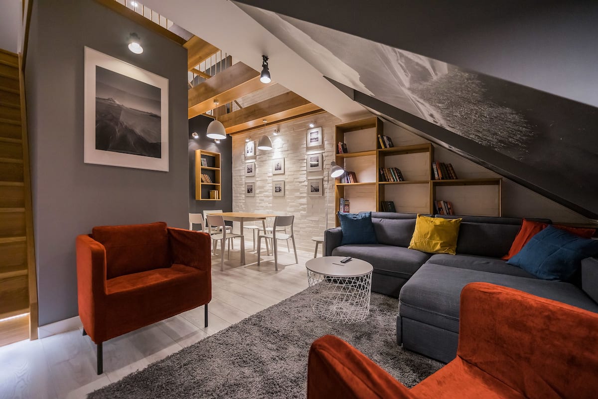 Un salon moderne avec un canapé, des fauteuils et un coin repas.