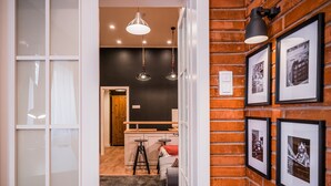 A modern interior with a brick wall, framed pictures, and pendant lighting.