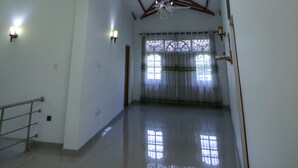 Un interior espacioso con techo alto, vigas a la vista y una serie de luces colgantes.