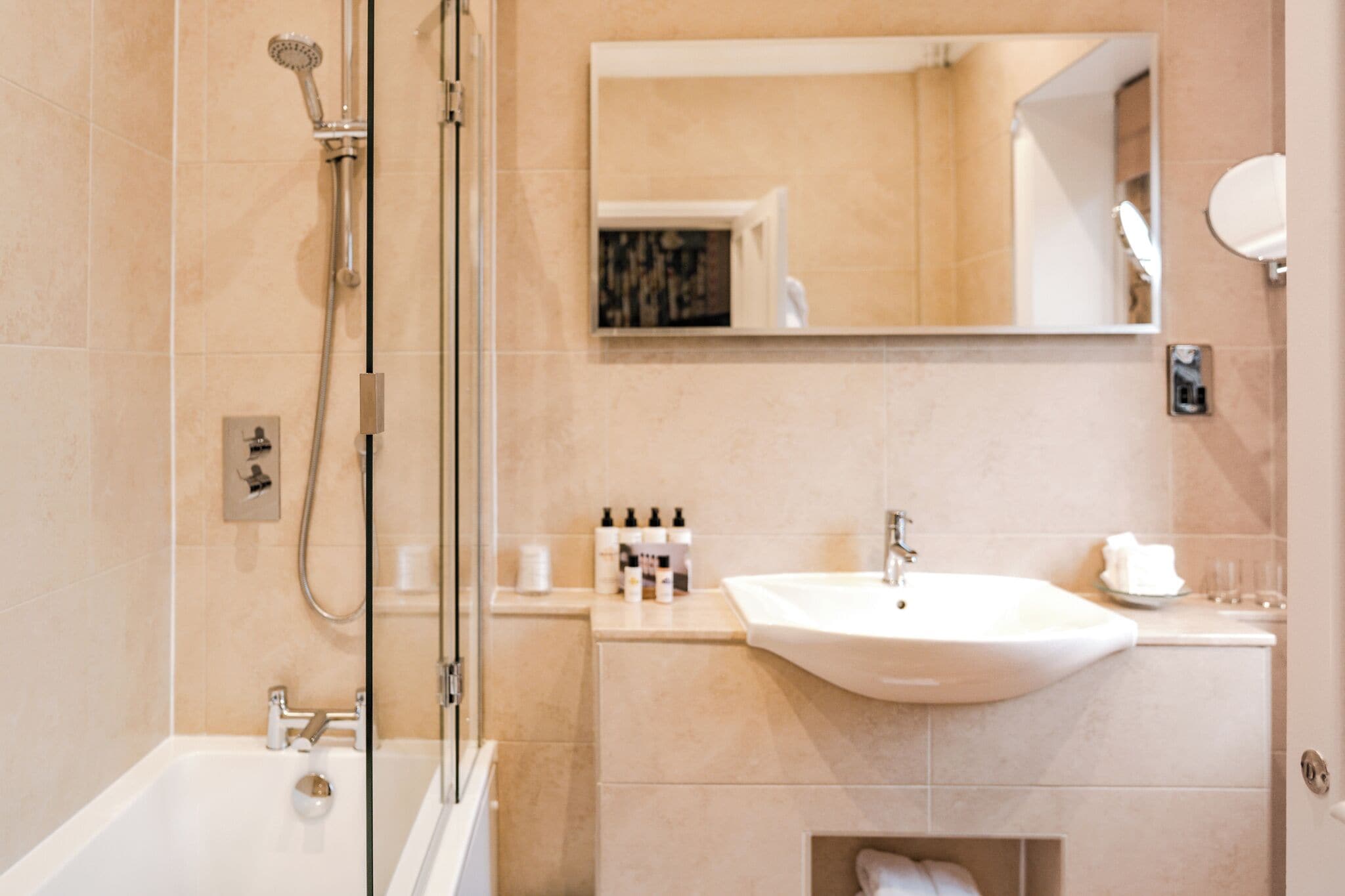A modern bathroom with a bathtub, shower, sink, and mirror.