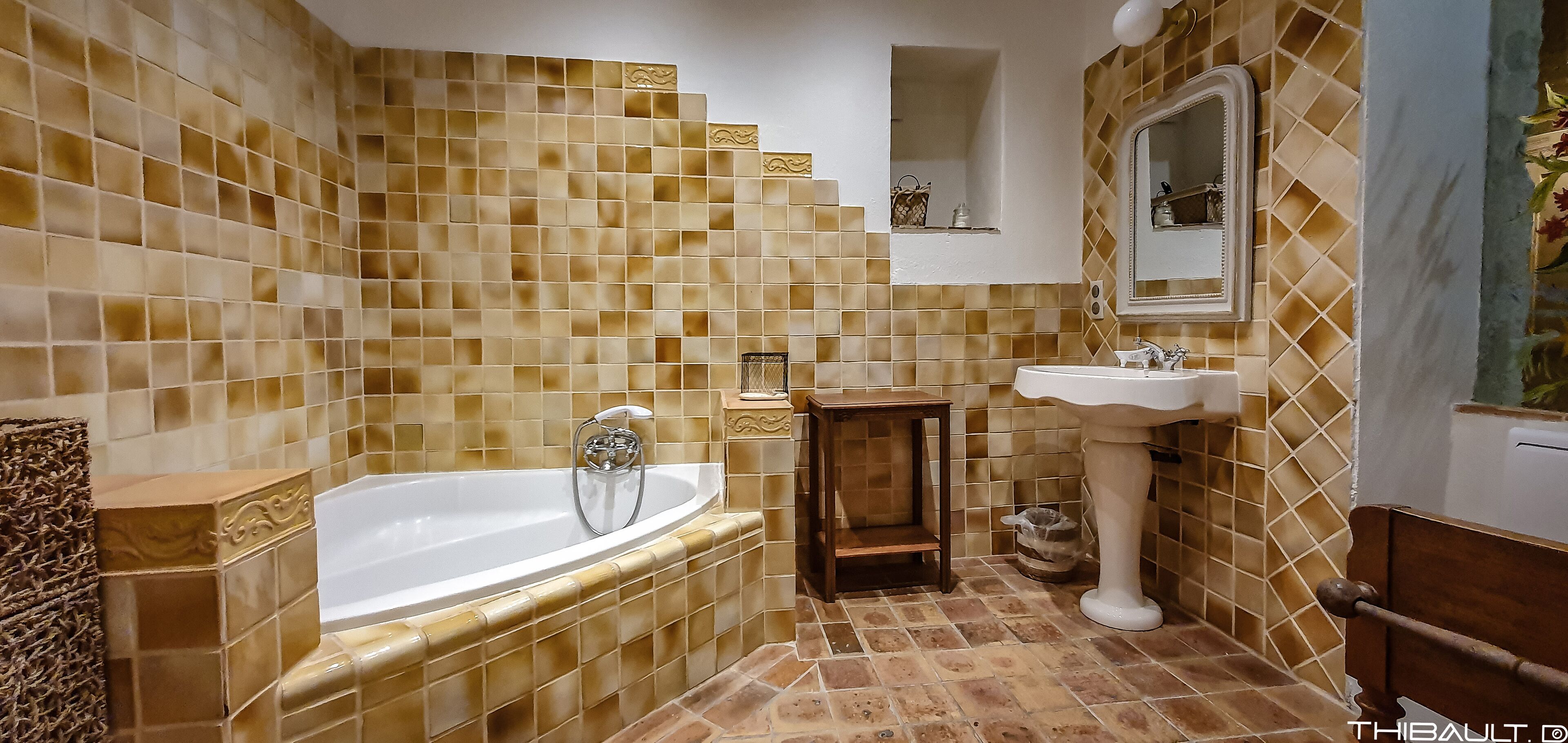 Une salle de bain avec une baignoire, un lavabo et un miroir.
