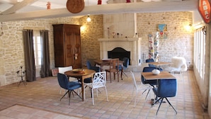 Un interior rústico con paredes de piedra, una chimenea y un letrero que dice 'Tabac'.