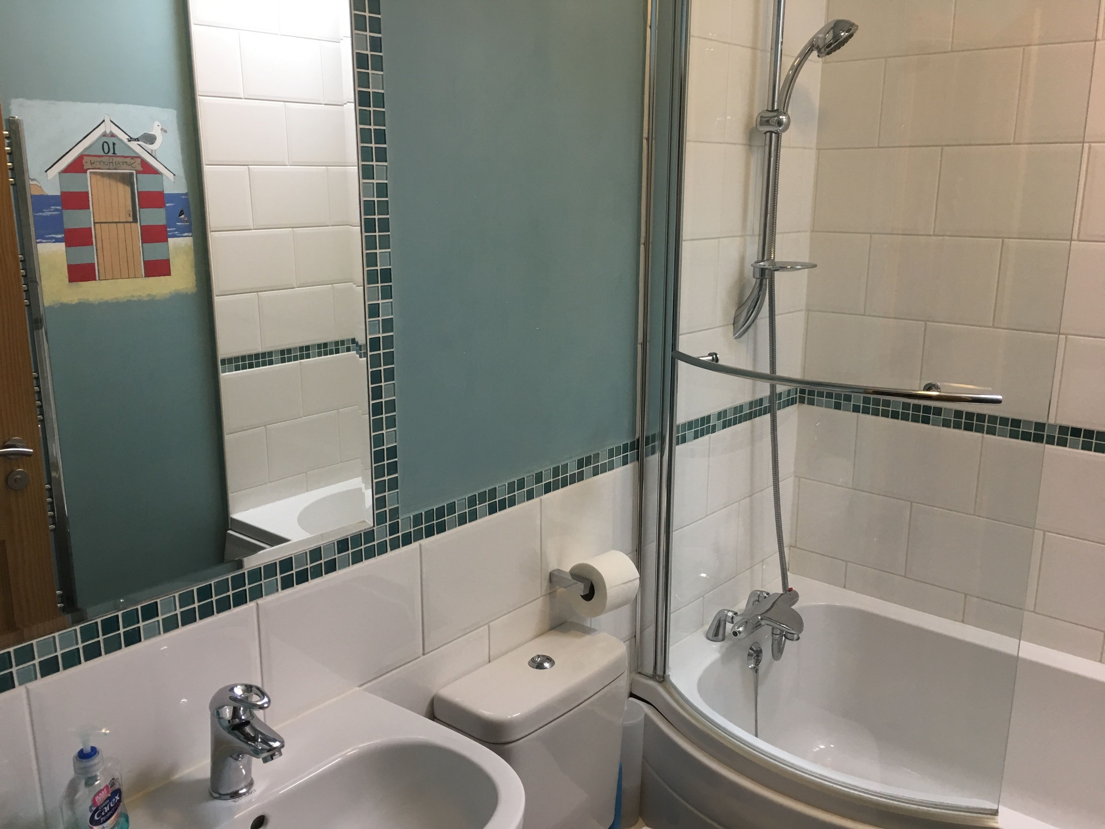 Et badeværelse med badekar, håndvask og toilet.