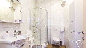 A modern bathroom with a glass-enclosed shower, a white sink, and a toilet. - Villa Ragusa Palace-Funjestra (Dubrovnik)
