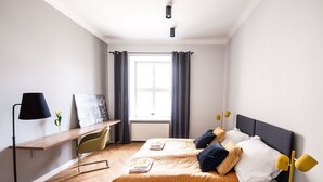 Ein modernes Hotelzimmer mit Bett, Schreibtisch und Stuhl.