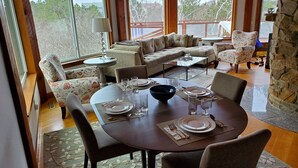 A dining area with a round table set for four, surrounded by floral-patterned chairs.