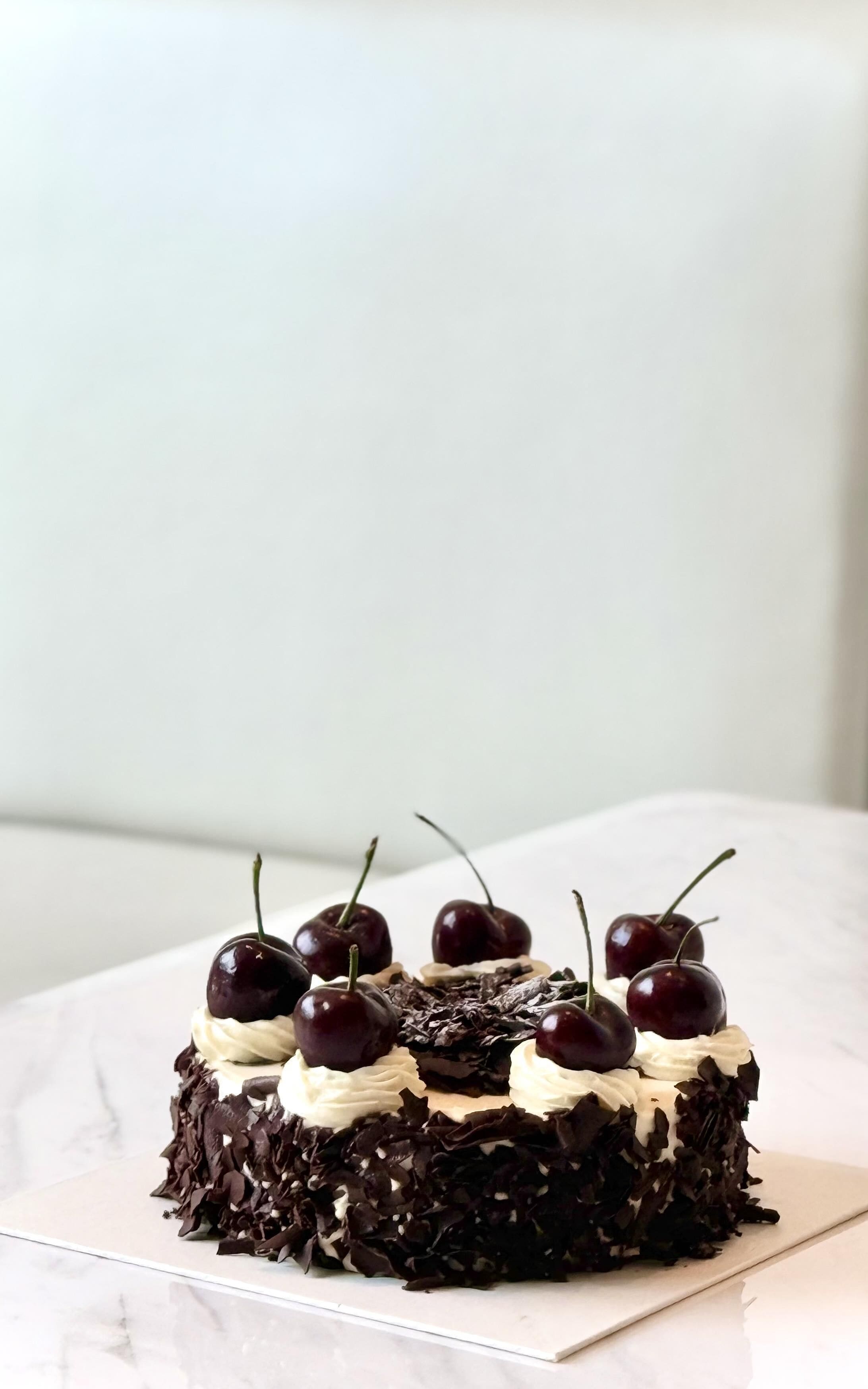 A dessert with whipped cream and cherries on a white plate.