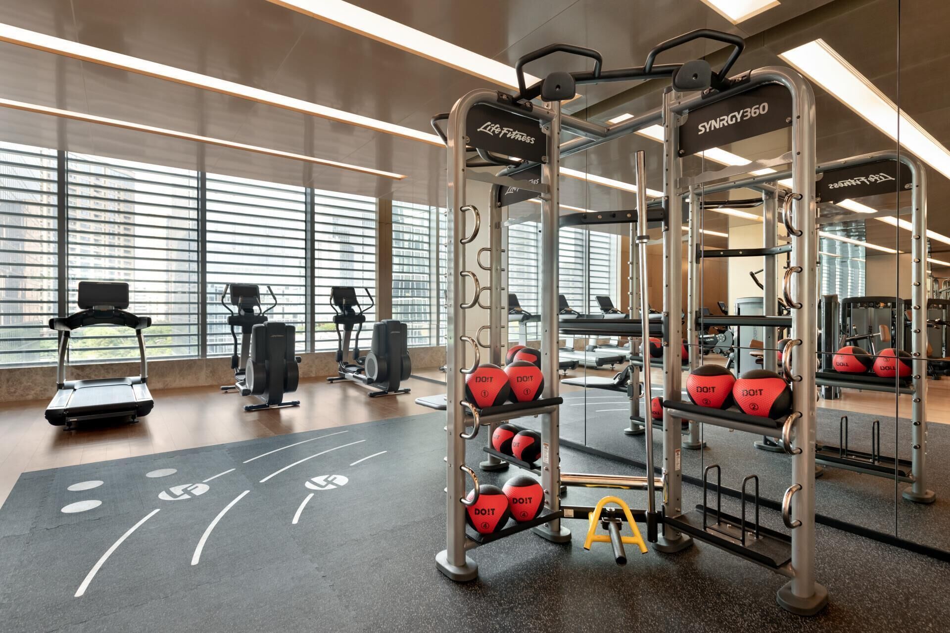 A gym with exercise equipment, treadmills, and weights.
