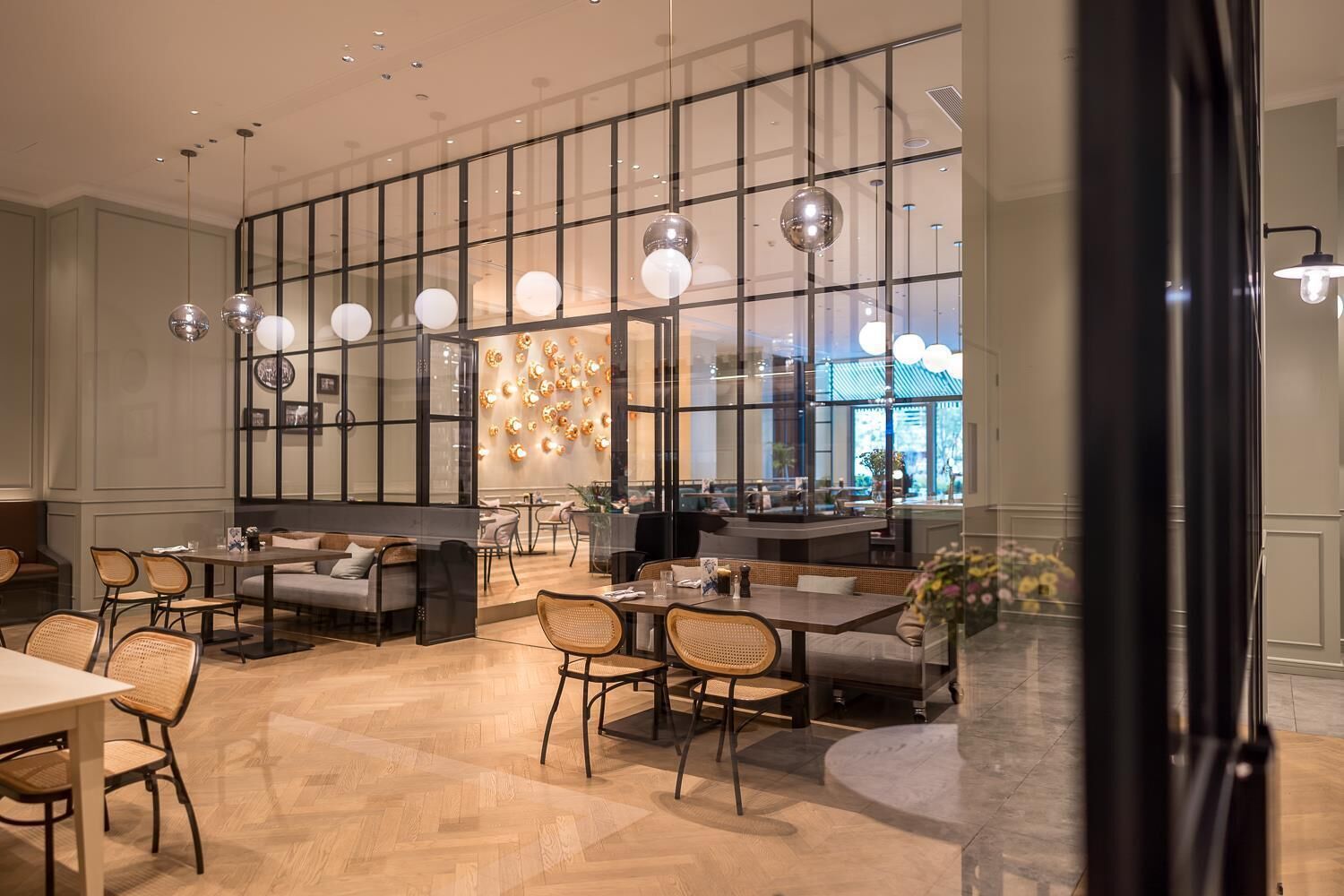 Un interior modern amb zona de dinar, espais d'seure i una finestra gran amb il·luminació decorativa.