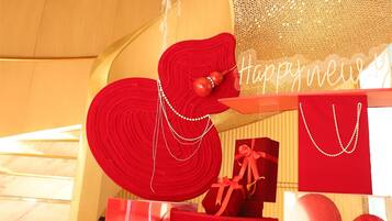 Un intérieur décoré dans un esprit festif, avec un grand cadeau rouge et une pancarte portant l’inscription « Bonne année ».