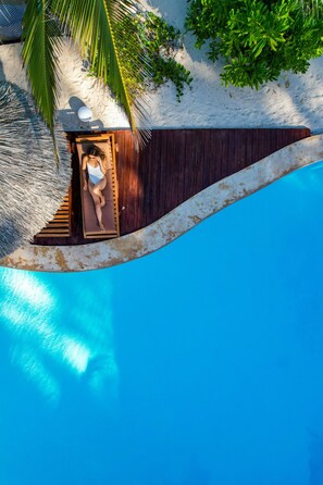 حمّام سباحة خارجي، مظلات على حمّام السباحة، مقاعد للتشمس