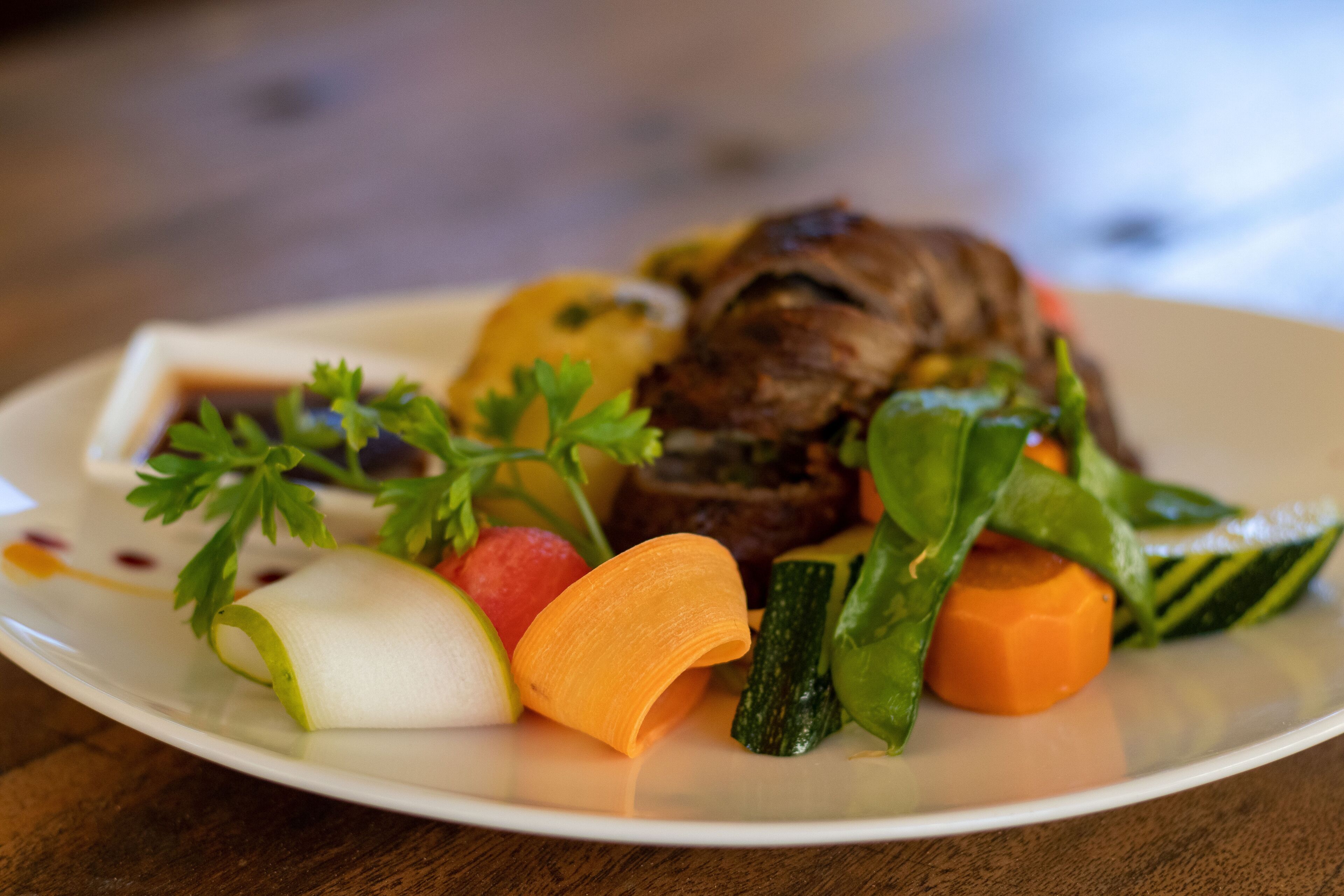 A plate of food with various vegetables and a piece of meat.
