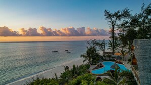 A resort with a pool, beach, and ocean view. - Clove Island Villas & SPA (Makunduchi)