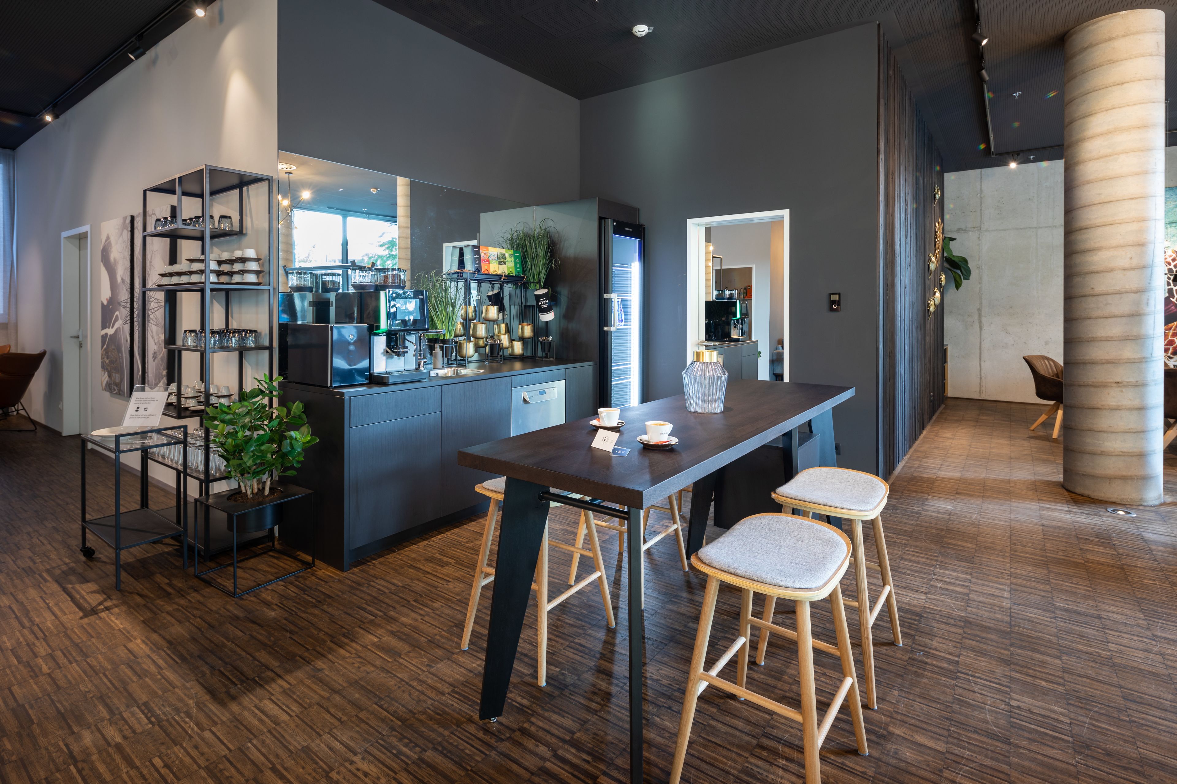 Una cocina moderna con una isla central, taburetes de bar y una cafetera.