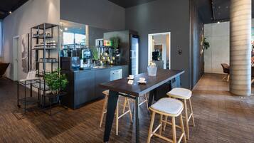 Una cocina moderna con una isla central, taburetes de bar y una cafetera.