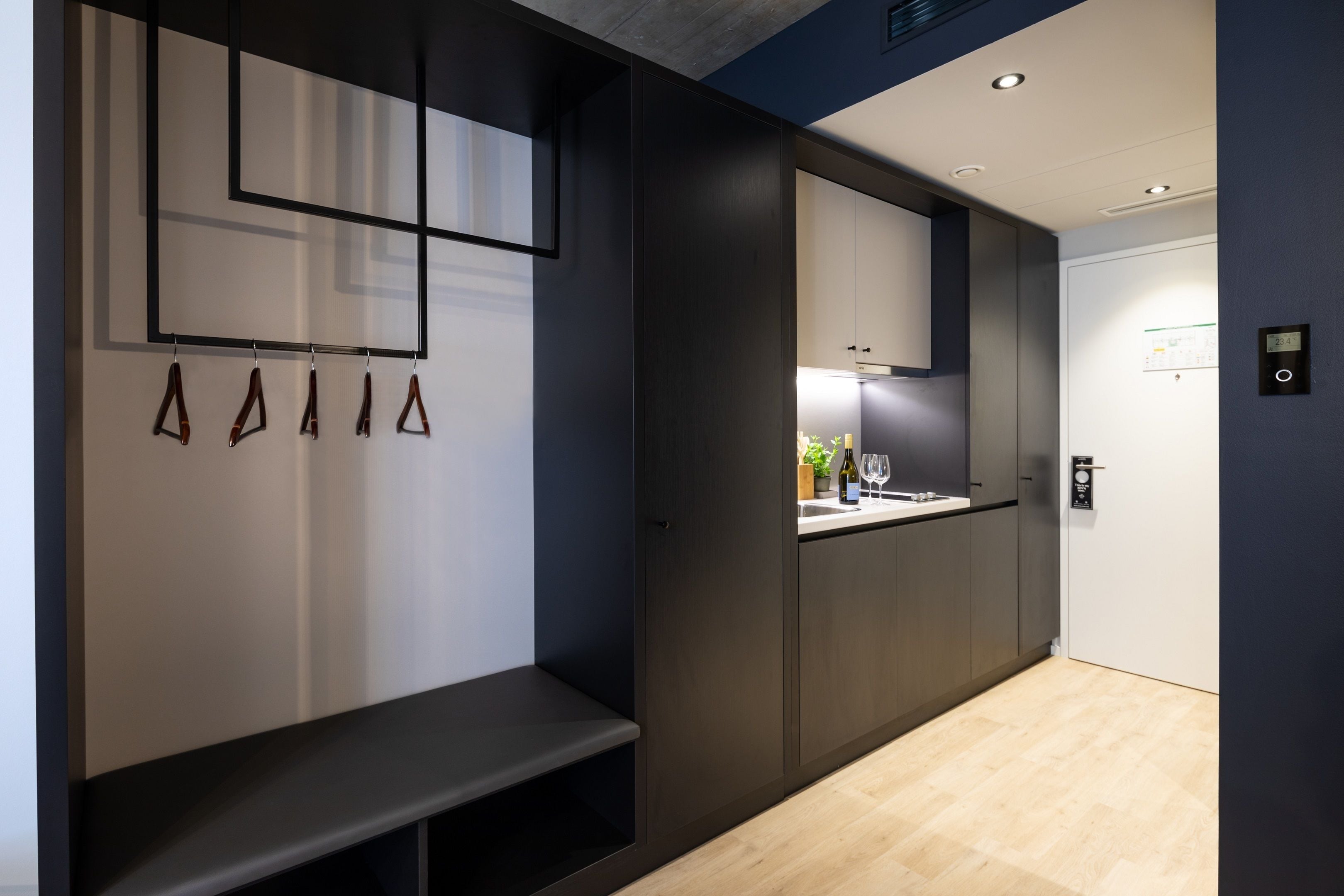Een moderne keuken met donkere kastjes, een ingebouwde bank en een hanglamp.