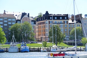 A marina with boats docked, surrounded by multi-story buildings with varied architectural styles.