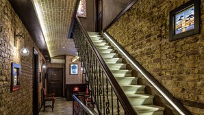 Un escalier avec un mur en briques et une rampe en bois.