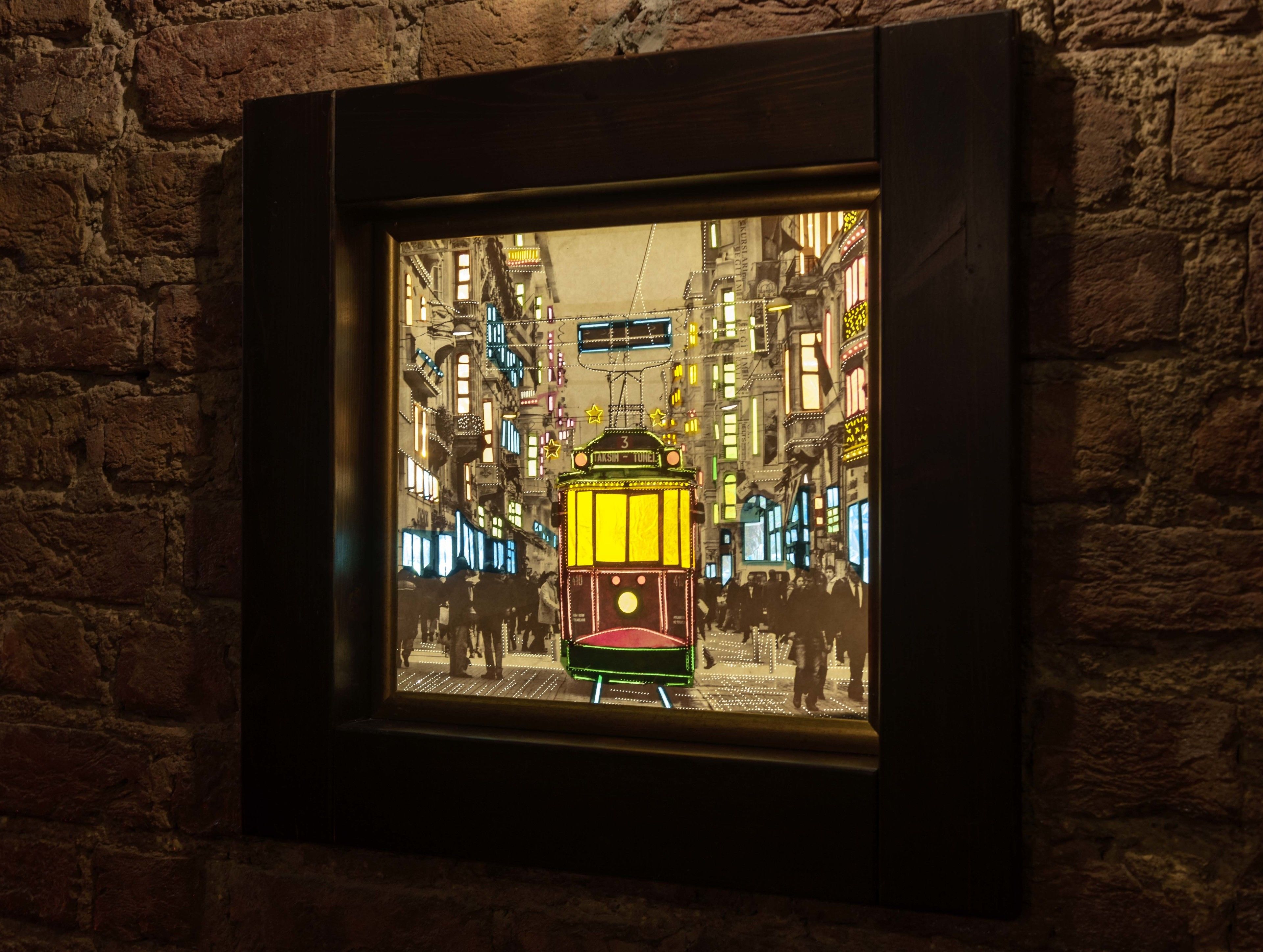 A framed artwork of a tram in a city street.
