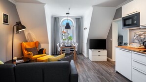 A modern apartment with a dining area, kitchen, and living space. - Apartment Hotel Rosenhof (Kuehlungsborn)