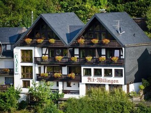 A two-story building with balconies adorned with flower boxes, labeled "Cafe" and "Alt-Willingen".