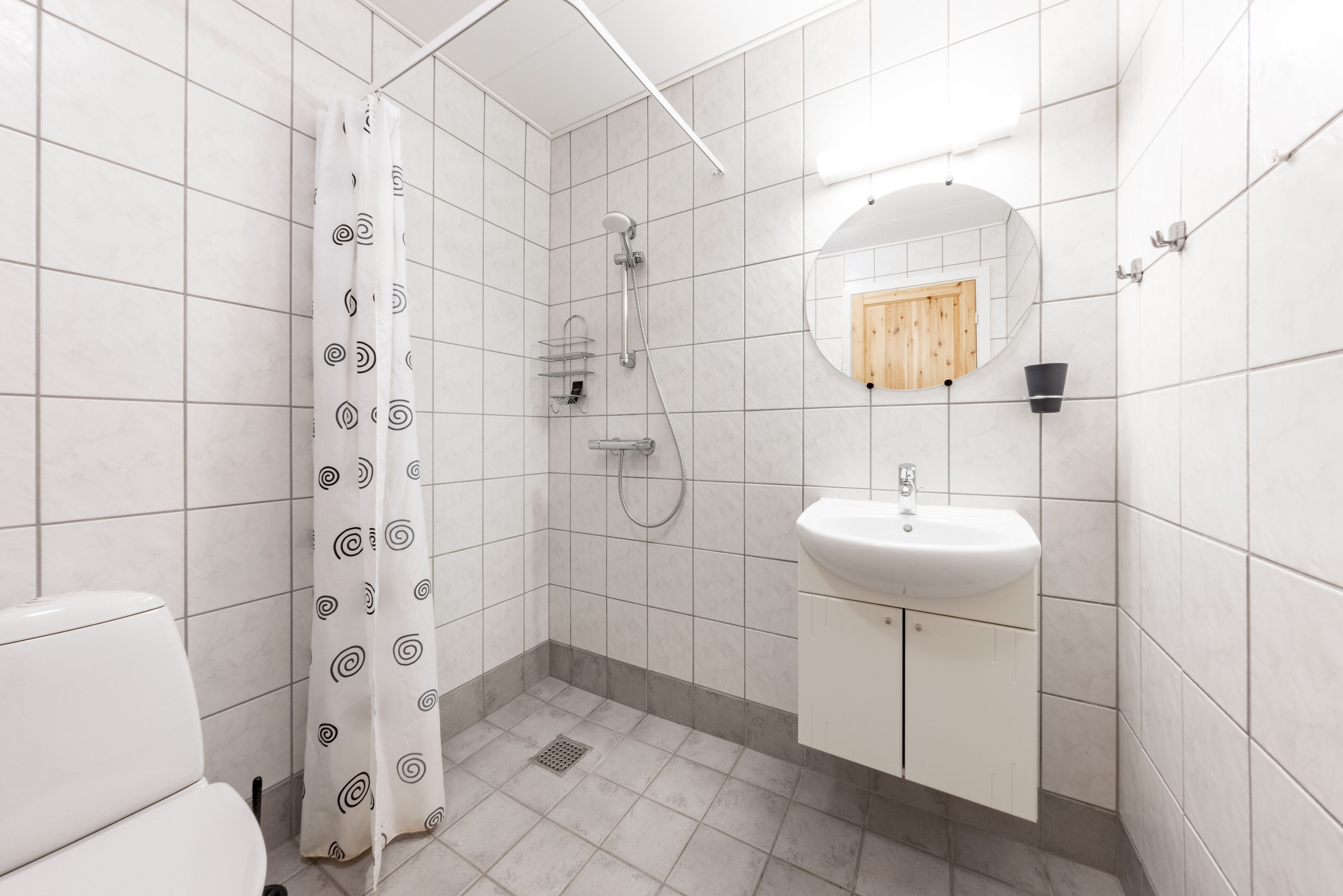 A bathroom with a shower, toilet, and sink.