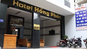 The entrance to Hotel Hong Phuc with a reception desk, seating area, and a signboard with amenities listed. - Hotel Hong Phuc (Quy Nhon Nam)