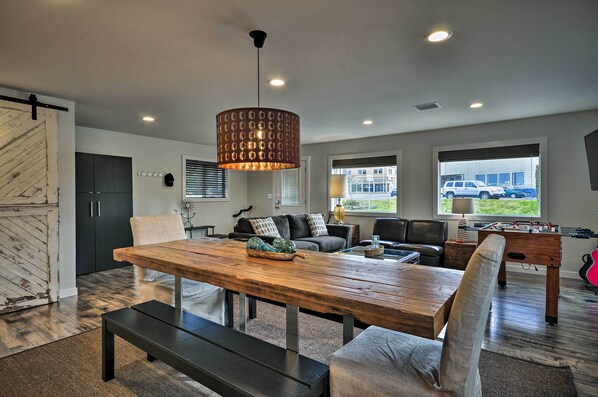 Relax and socialize in this inviting space with a central dining table, comfortable seating, and a foosball table.