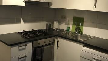 Een koelkast met diepvriezer, een microgolfoven, een oven, een kookplaat