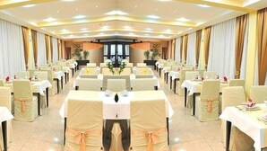 A banquet hall with rows of tables, each set with white tablecloths and chairs, and a central aisle. - Hotel Yu (East Sarajevo)
