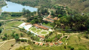 An aerial view of a resort with a swimming pool, tennis courts, and a lake. - Hotel Termópolis (Sao Sebastiao do Paraiso)