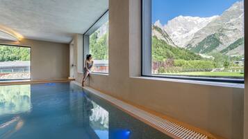 Una grande piscina interna con vista sulle montagne.