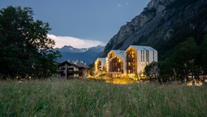 A modern building with large windows and a mountain backdrop. - TH Courmayeur (Courmayeur)