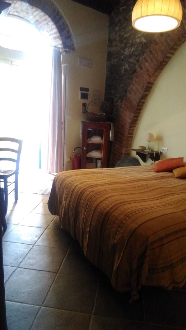 Un dormitorio con cama, una silla, un escritorio y una lámpara.