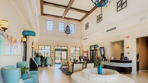 A spacious lobby with a reception desk, seating area, and artwork on the walls.