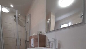 Un baño moderno con inodoro, lavabo y ducha.
