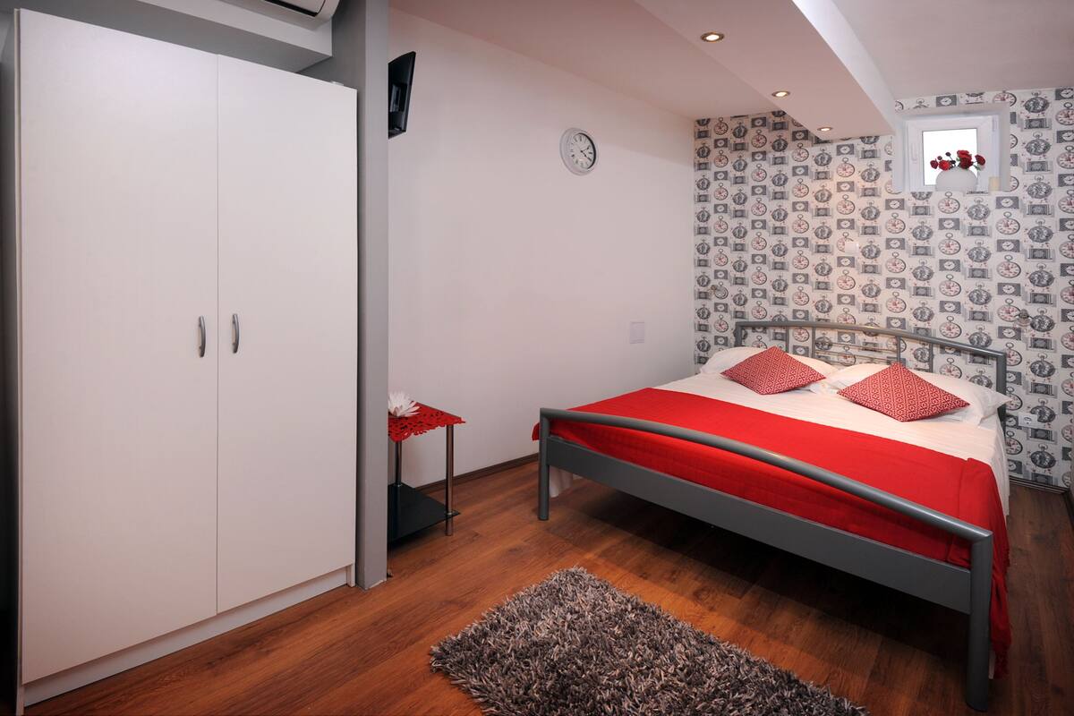 Une chambre à coucher avec un lit, une armoire et une petite table.