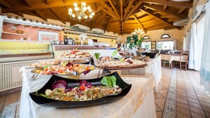 Un buffet proposant divers plats, un lustre et un plafond en bois.
