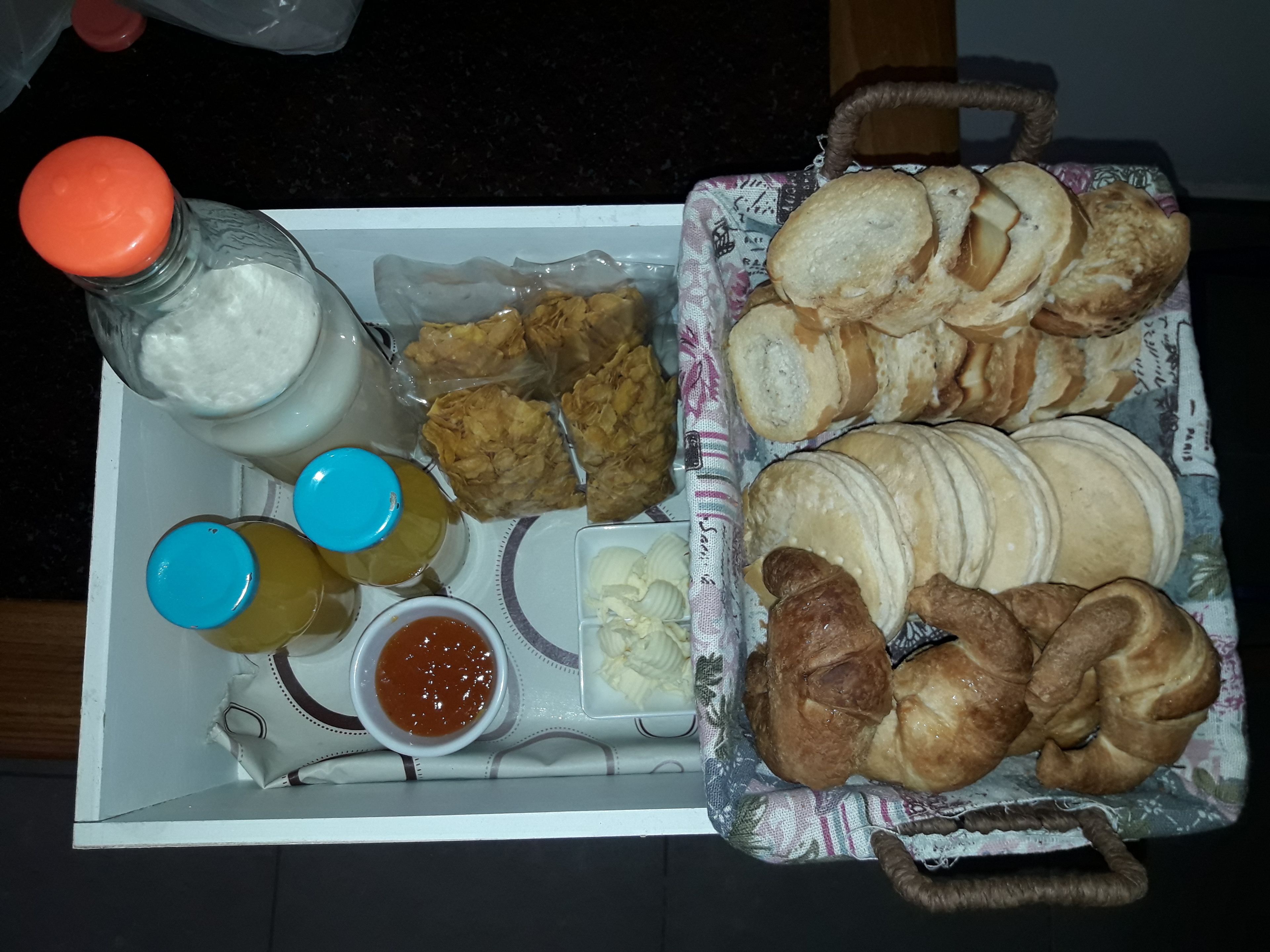 Una bandeja con diversos alimentos, incluyendo pan, pasteles y salsas.