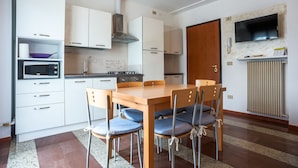 Eine moderne Küche mit weißen Schränken, einem Holztisch und blauen Stühlen.