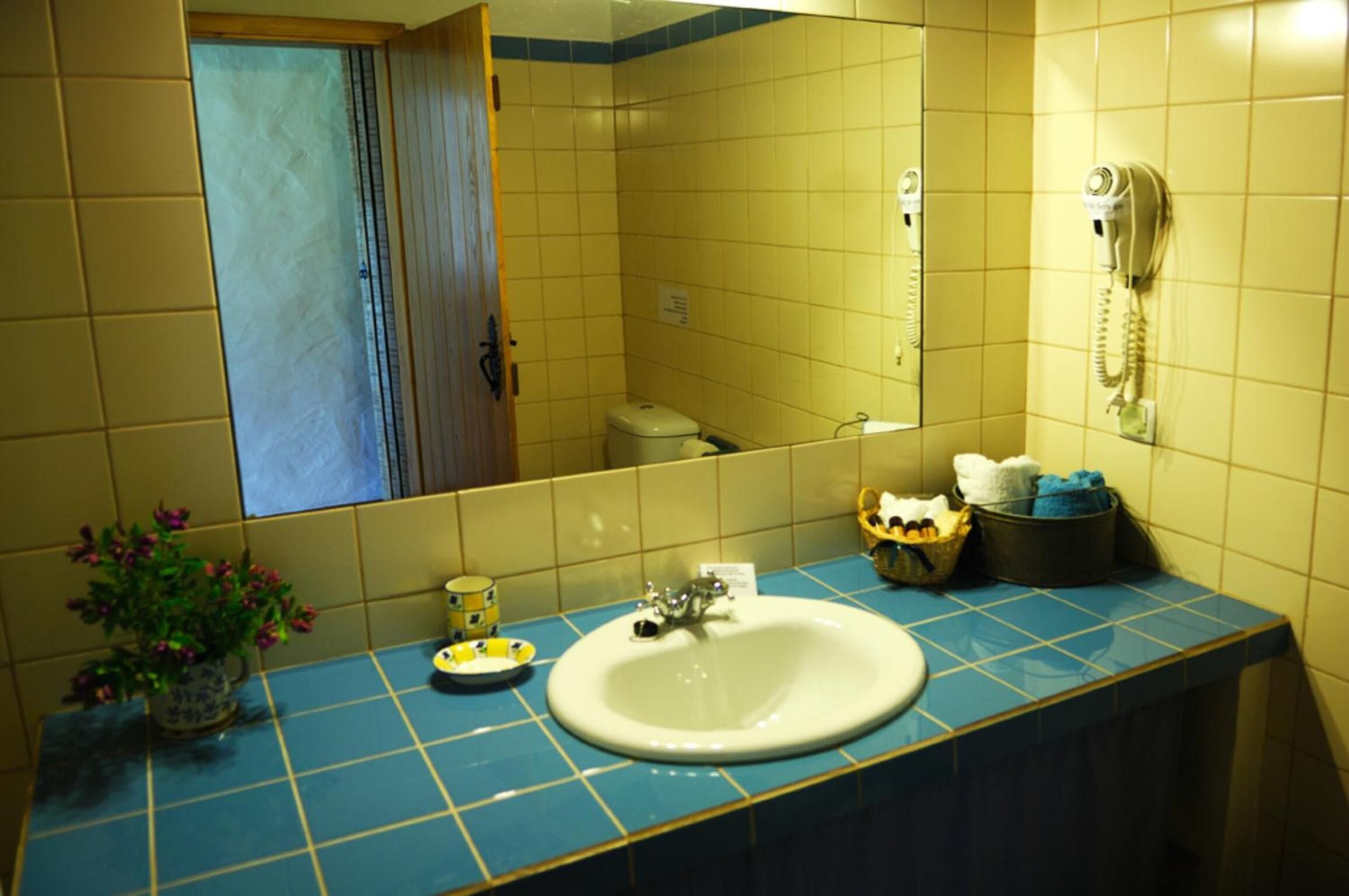 A bathroom with a sink, mirror, and a telephone.