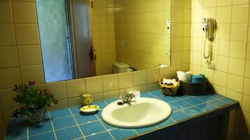 A bathroom with a sink, mirror, and a telephone.