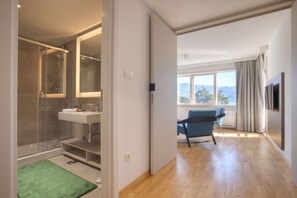 Suite, vista città | Area soggiorno | TV LED